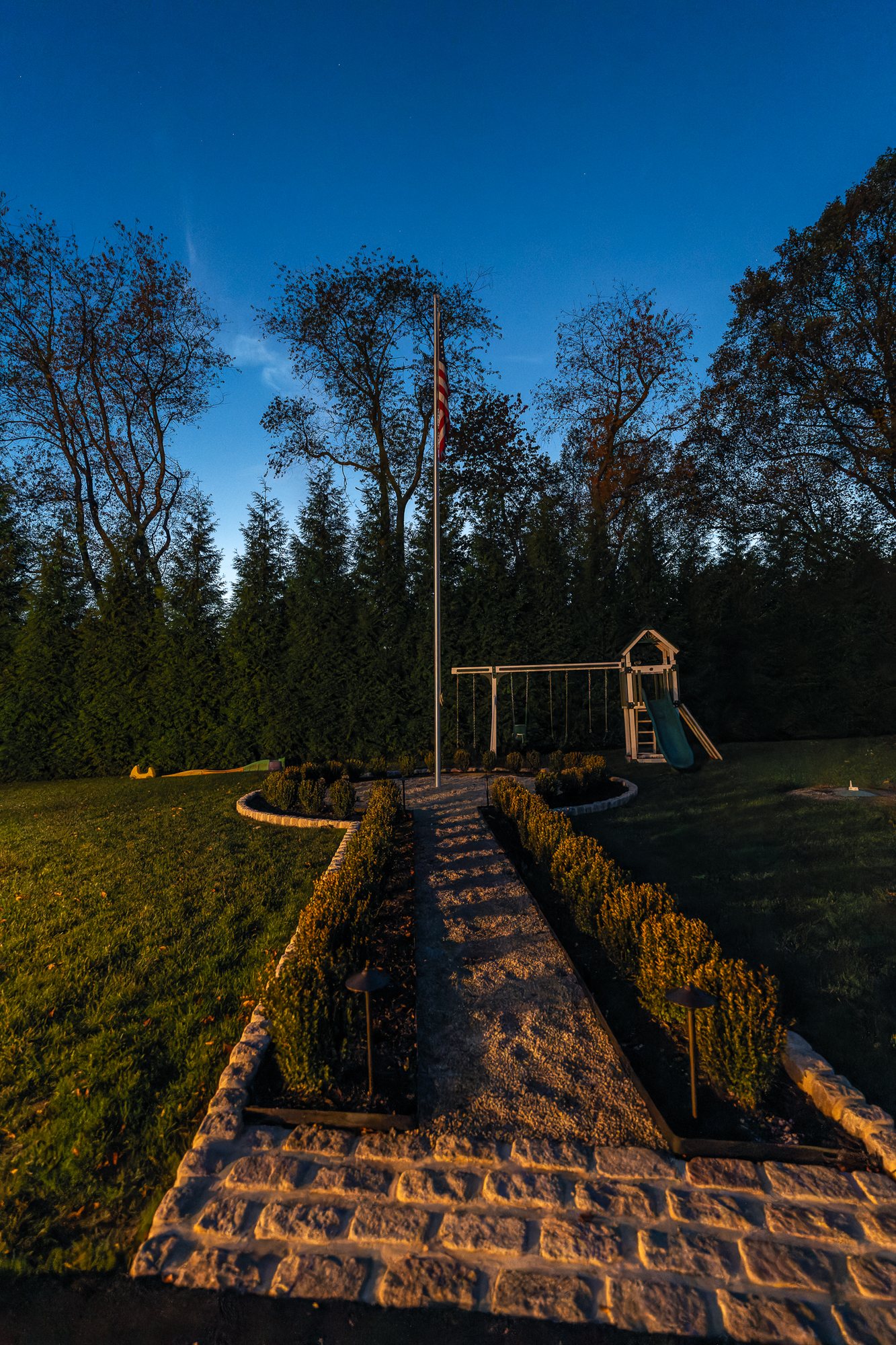 Path lighting Main Line PA — lit stone walkway and garden steps at dusk